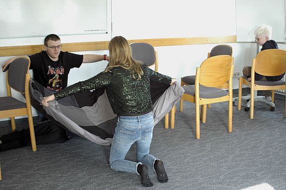 Theatergruppe, realisiert eine Maschine, Dominik und Lenka (Rückenansicht), rechts wartet der der Stempler Mika. Foto Robert Heuser